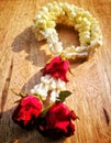 Jasmine with rose garlands lay on the wooden desk. Royalty Free Stock Photo