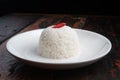 Jasmine steamed rice on the white plate on rustic wooden kitchen table