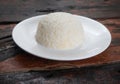 Jasmine rice on the white plate on rustic wooden kitchen table