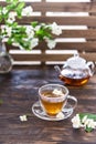 Jasmine tea in transparent cup, jasmine flowers and teapot on wooden table. Copy space. Tea party Royalty Free Stock Photo