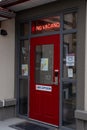 A NO VACANCY sign illuminated at the door to the town of Jasper Hostel above a red door Royalty Free Stock Photo