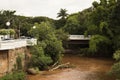 Jau / Sao Paulo / Brazil - 02 21 2020: Bridge and street at the center of the city with heavy vegetation and muddy river Royalty Free Stock Photo