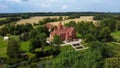 Jaunmoku Brick Medieval Castle Near Tukums, Latvia at Pond With Fontain in Clear Sunny Summer Day From Above Top View.