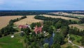 Jaunmoku Brick Medieval Castle Near Tukums, Latvia at Pond With Fontain in Clear Sunny Summer Day From Above Top View.