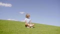 Jaunty young woman golfer sitting on the green