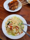 Javanese boiled noodles with shredded chicken, eggs, vegetables and grilled chicken satay