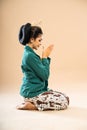 javanese woman in green kebaya sitting facing left on the