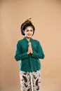 javanese woman in green kebaya standing and put her hands together