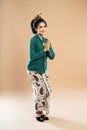 javanese woman in one set of kebaya standing with hands put together