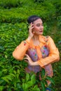 a Javanese woman on vacation in a tea garden wearing a yellow dress