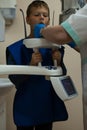 Jaw computed tomography, check up teeth in dental clinic. Boy in vest with open mouth on x-ray diagnostics. CT scanning