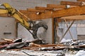 Jaws of an excavating machine destroy a brick wall Royalty Free Stock Photo