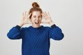 Jazz hands never come out of style. Portrait of emotive good-looking female with red hair combed in bun hairstyle