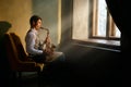 Jazz musician playing saxophone at the window Royalty Free Stock Photo