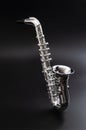 Jazz nightclub, blues music and woodwind instrument concept theme with a silver saxophone floating over a black background