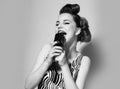 Jazz. Young woman singer at the microphone. Music pinup girl. Pop art retro style. Royalty Free Stock Photo