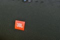 JBL dark green bluetooth speaker. closeup texture of fabric audio speakers. Macro mode. logo JBL - American company that produces