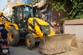 JCB earth moving machine working on a road. JCB bucket loader is repairing a section of a dirt road. Road is expanding in