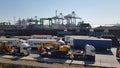 JCB excavator carried by truck trailer at berth of cargo port TIS