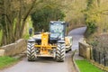 Jcb loader pulling trailer over a bridge