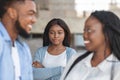 Jealous afro girl watching her boyfriend flirting with another woman Royalty Free Stock Photo