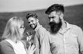 Jealous concept. Man with beard jealous aggressive because girlfriend interested in handsome passerby. Passerby smiling Royalty Free Stock Photo