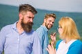 Jealous concept. Man with beard jealous aggressive because girlfriend interested in handsome passerby. Passerby smiling Royalty Free Stock Photo