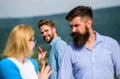 Jealous concept. Man with beard jealous aggressive because girlfriend interested in handsome passerby. Passerby smiling Royalty Free Stock Photo