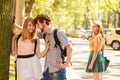 Jealous girl looking at flirting couple outdoor. Royalty Free Stock Photo