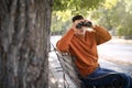 Jealous man with binoculars spying on ex girlfriend in park Royalty Free Stock Photo