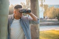 Jealous man with binoculars spying on ex girlfriend in park Royalty Free Stock Photo