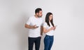 Jealous man peeking into girlfriend's cellphone and trying to read her messages on white background Royalty Free Stock Photo