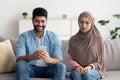 Jealous Middle Eastern Wife Suspecting Infidelity While Husband Texting Indoor