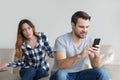 Jealous suspicious wife arguing with obsessed husband holding phone