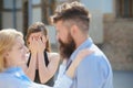 Jealous of their love. Jealous girl look at couple in love on street. Bearded man cheating his woman with another Royalty Free Stock Photo