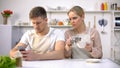 Jealous woman peeping in husbands smartphone, relationship crisis, distrust Royalty Free Stock Photo