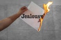 Jealousy text burning on paper