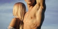 Jealousy. Woman with blond hair standing at muscular male chest Royalty Free Stock Photo