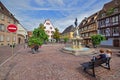 Wide view of old town square with Roesselmann Fountain & bench at Colmar, Grand Est region of northeastern France Royalty Free Stock Photo