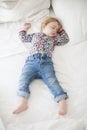 Jeans baby sleeping on white bed Royalty Free Stock Photo