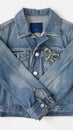 Jeans denim woman jacket with vintage brooch on white background. Fashion outfit
