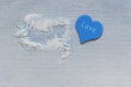 Jeans fabric torn with a blue heart and a word love. Royalty Free Stock Photo