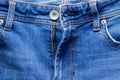 Jeans front with zipper open, button and pockets. Bright blue denim fabric texture background Royalty Free Stock Photo