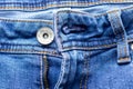 Jeans front with zipper open, button and pockets. Bright blue denim fabric texture background Royalty Free Stock Photo