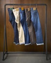 Jeans hanging on a rack with a wooden background