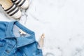 Jeans jacket, bottle of perfume, striped summer sandals on marble background. Flat lay design composition with retro fashioned fem