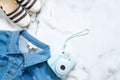 Jeans jacket, instant photo camera, striped summer sandals on marble background. Flat lay design composition with retro fashioned