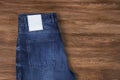 Jeans label mockup, denim texture, isolated wooden background Royalty Free Stock Photo