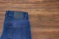 Jeans label mockup, denim texture, isolated wooden background Royalty Free Stock Photo