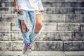 Jeans with large holes on the legs of a young teenage girl Royalty Free Stock Photo